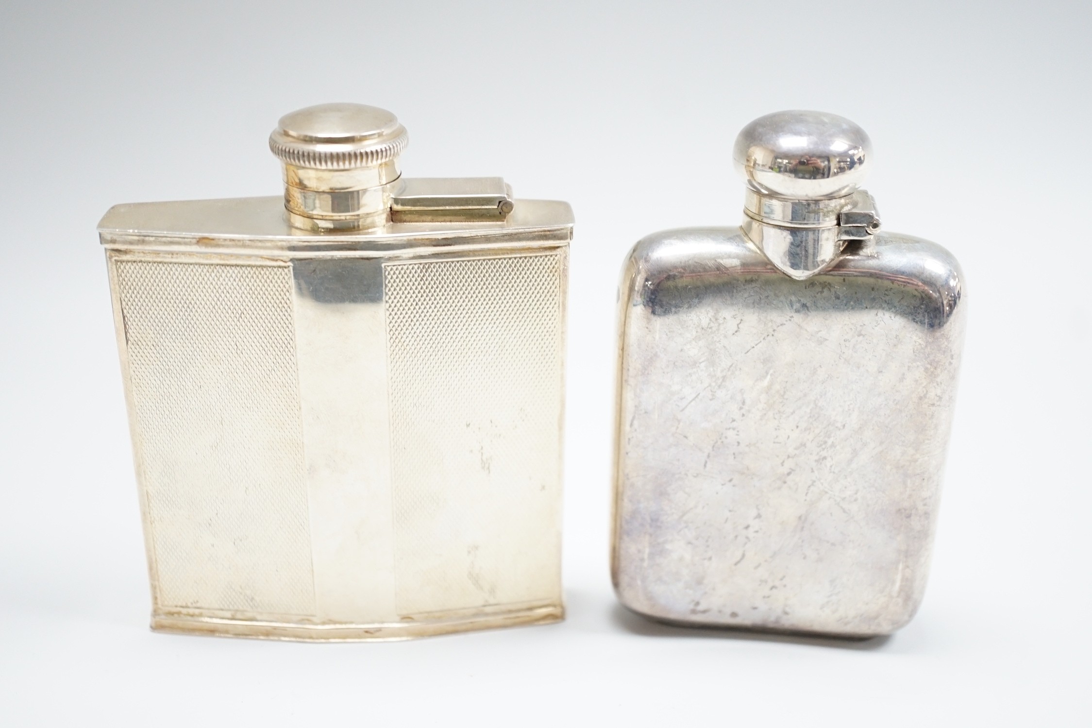 Two George V silver hip flasks, one with engine turned decoration, the latter William Base & Sons, Birmingham, 1927, 10.7cm, 7.7oz.